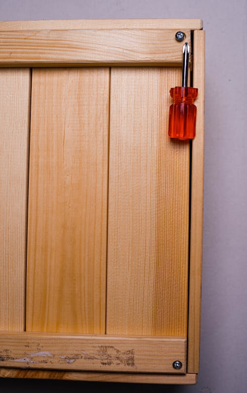 Red and Silver Screwdriver on Wooden Surface 