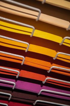 Vertical shot of a colorful paper rack organized by color, ideal for stationery enthusiasts.