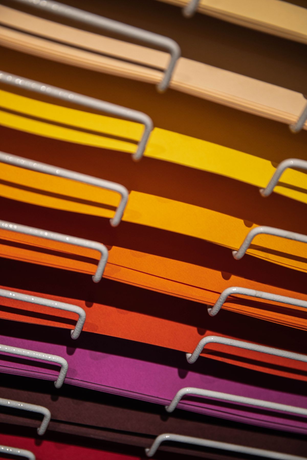 Coloured paper sheets sorted vertically in a file rack