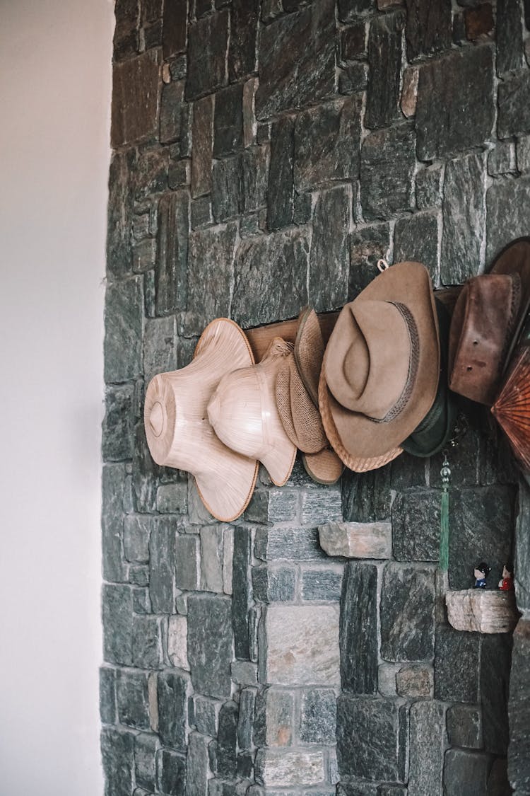 A Sun Hats Hanging On The Stone Wall