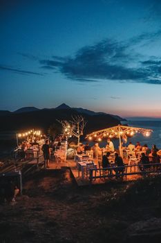 Enchanting seaside dining experience in Gökçeada, Türkiye, with sunset views and warm ambiance.