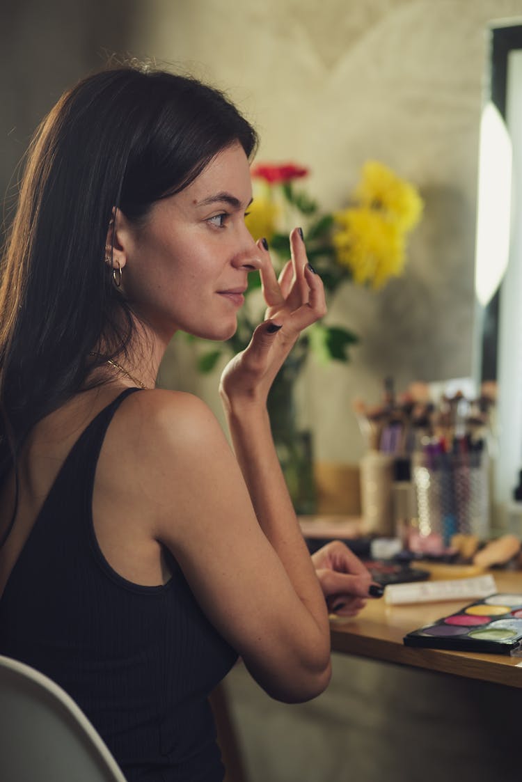 Woman In Black Tank Top Touching Her Face