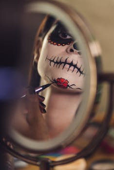 Close-up of a Hispanic woman applying Dia de Muertos makeup, reflecting in a mirror, capturing the cultural essence.