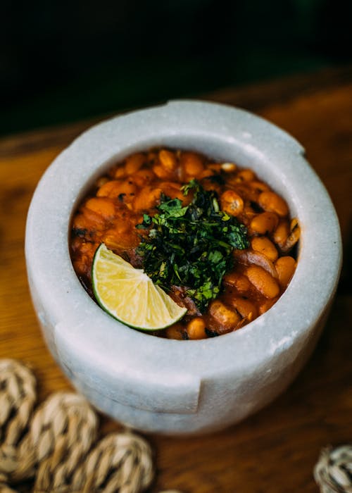 A Bowl of Cooked Beans with Lime Garnish