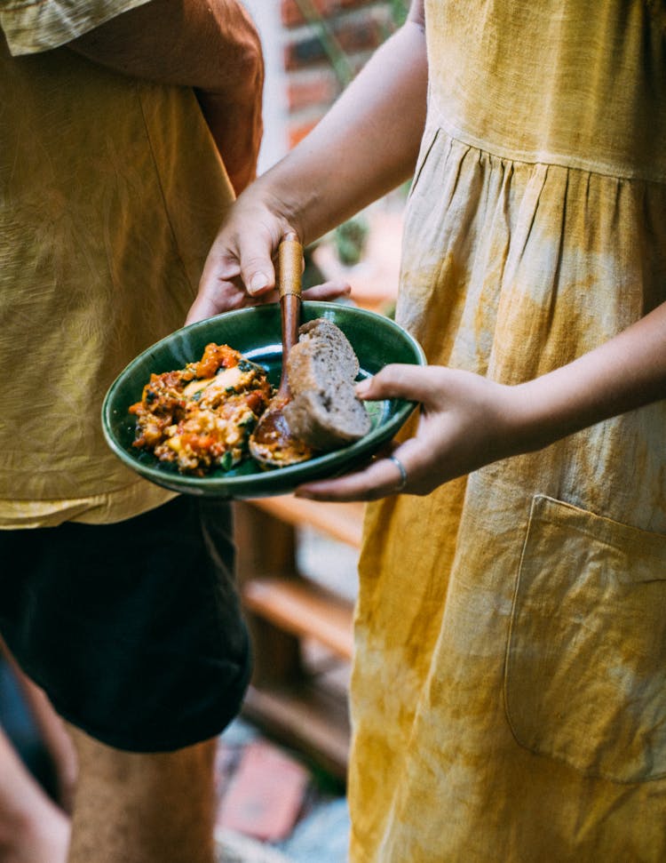 Woman Wearing A Tie Dye Dress Holding A Plate Of Food