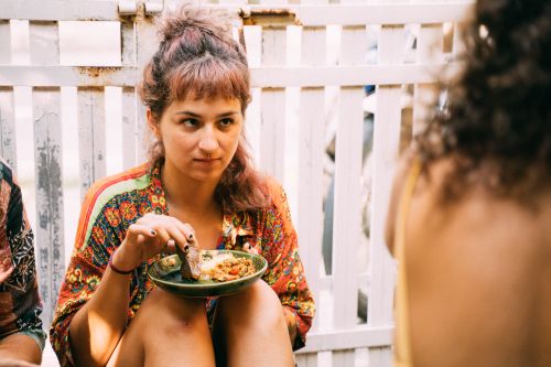 Free A young woman enjoys food outdoors, exuding a casual and relaxed vibe. Stock Photo