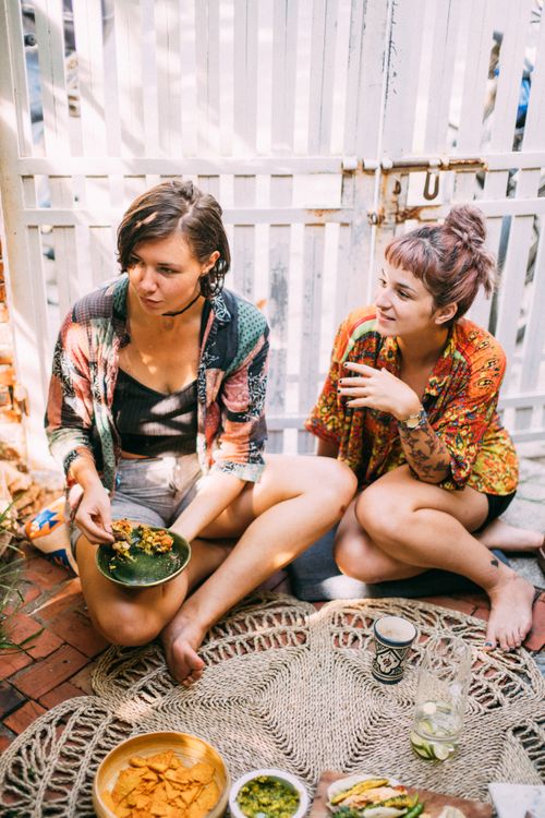 Free Two young women enjoy a casual outdoor meal and conversation. Stock Photo