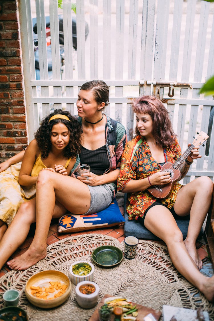 Mother And Daughters Having Fun And Sitting On Floor Cushions 