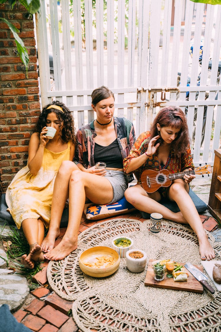 Mother And Daughters Having Fun And Sitting On Floor Cushions