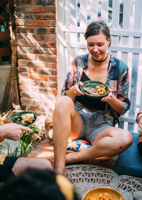 Free A lively and casual outdoor picnic gathering with friends enjoying food and laughter in a sunny setting. Stock Photo