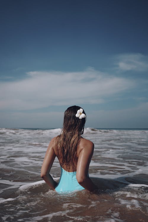 Back View of a Woman in Bathing Suit with Flower on Hair