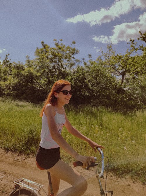 Free Photo of a Girl in a White Tank Top Riding a Bike Stock Photo