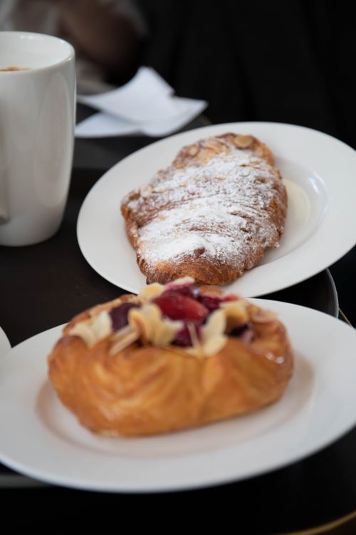 Free Tempting croissant and fruit pastry on plates with coffee. Perfect for breakfast or brunch. Stock Photo