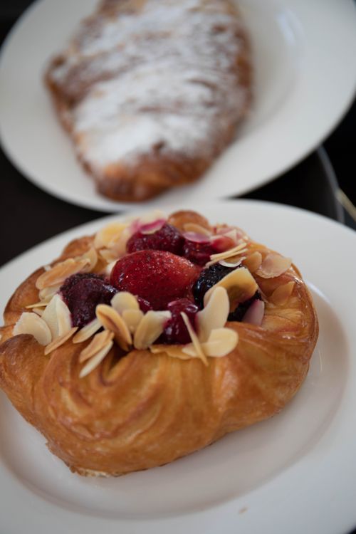 Free Close-up of a delicious almond and berry pastry served on a white ceramic plate. Stock Photo