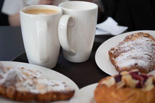 Free Delicious coffee and croissants served on a cozy cafe table, perfect for breakfast indulgence. Stock Photo