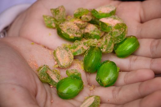 A close-up view of green candies held in hands, showcasing texture and color.