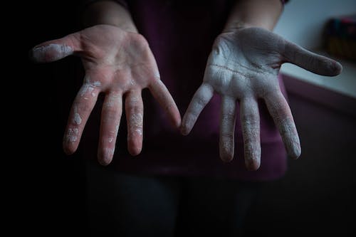 Close-up Photo of Person's Hands covered in White Paint 