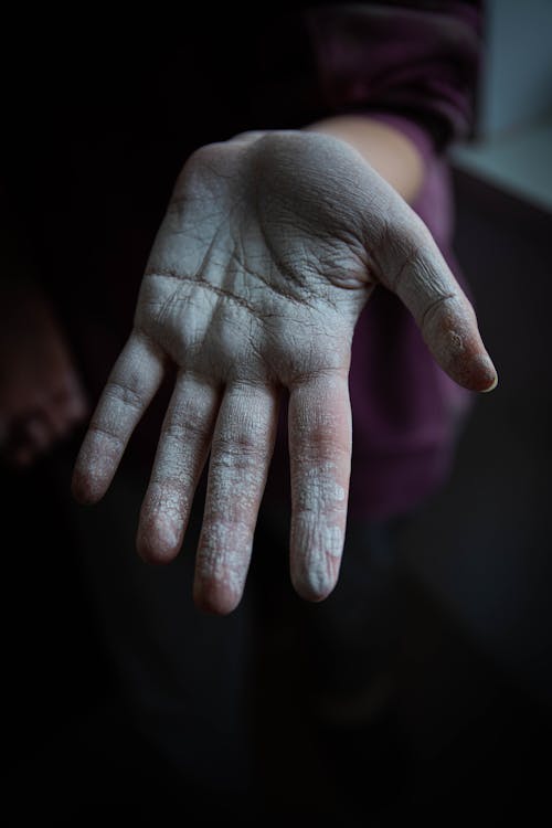 Close-up Photo of Person's Hand covered in White Paint 