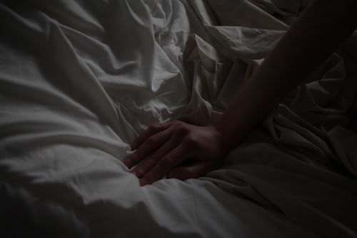 Free A close-up of a hand resting on white sheets, creating a sense of calm. Stock Photo