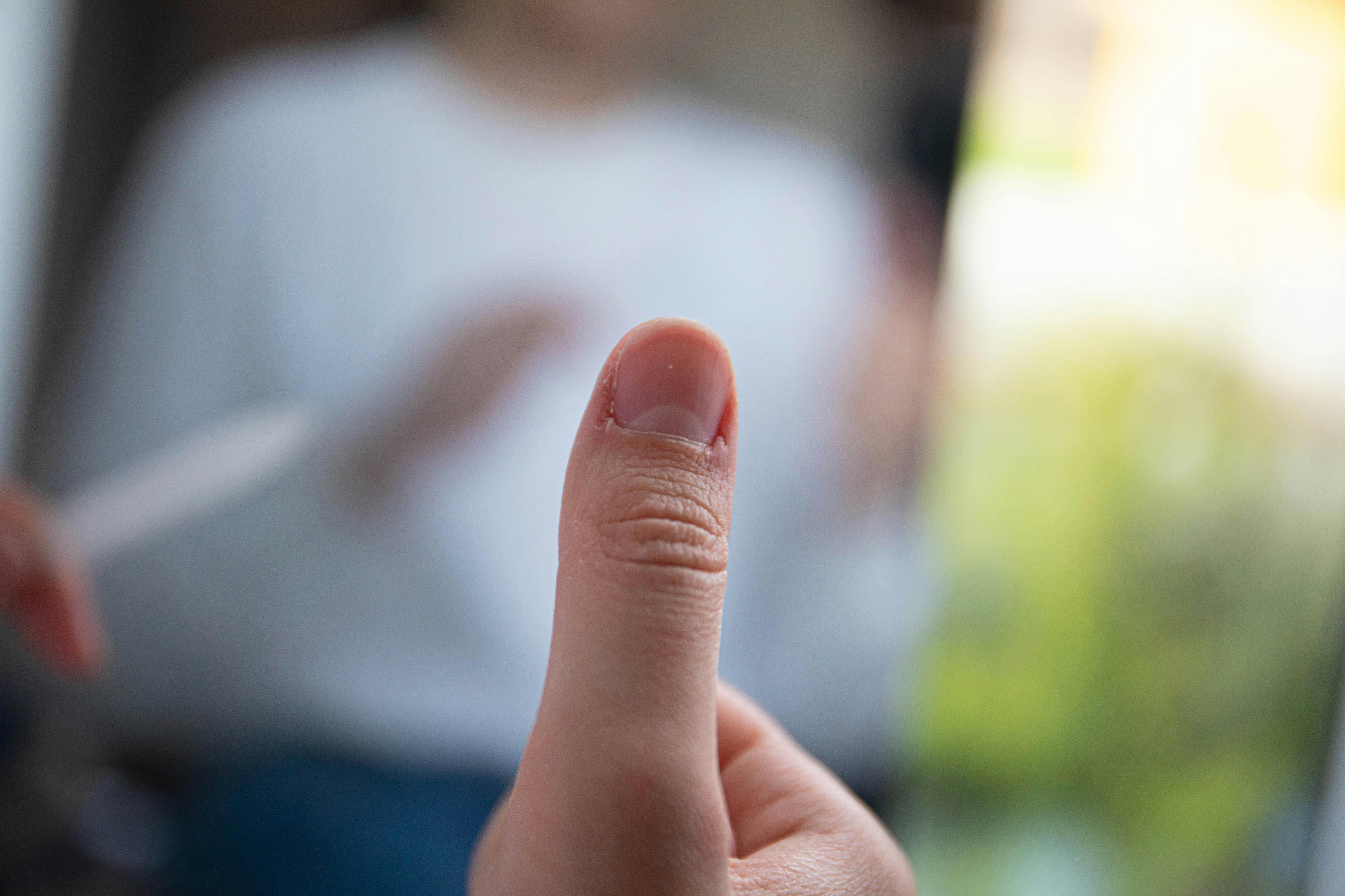 Free Detailed view of a thumb with a blurred background, showcasing texture and focus. Stock Photo
