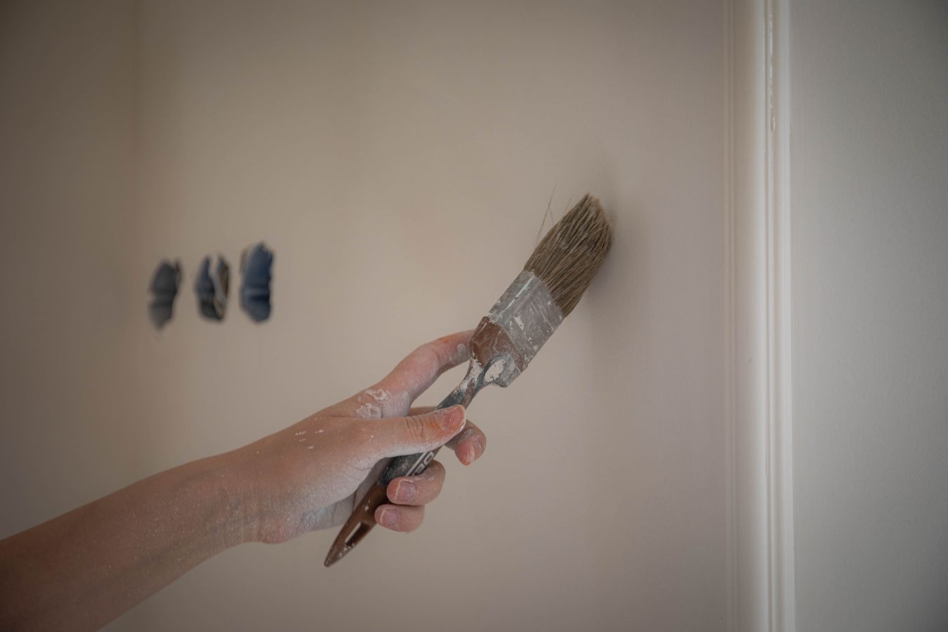 Close-up of a decorator applying paint carefully with a brush