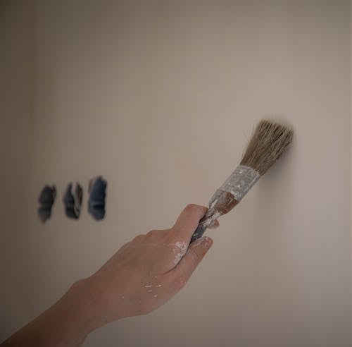 A Person Holding Brown Paintbrush