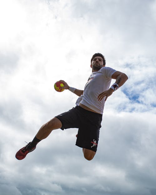 Free Photo of a Man Midair Holding a Ball Stock Photo