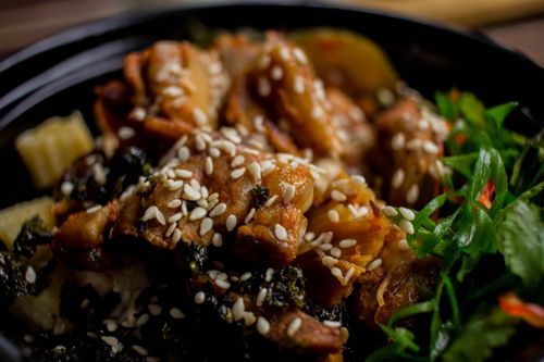 Free Mouth-watering sesame chicken dish with fresh greens, perfect for food enthusiasts. Stock Photo