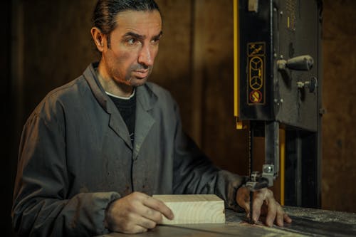 Man in Gray Dress Shirt Operating Band Saw