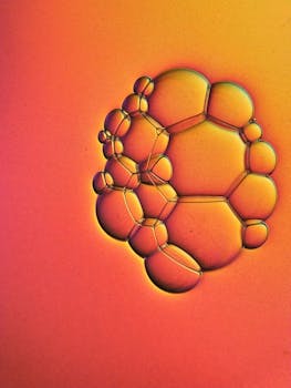 Vibrant macro photo of soap bubbles creating a mesmerizing pattern set against a gradient background.