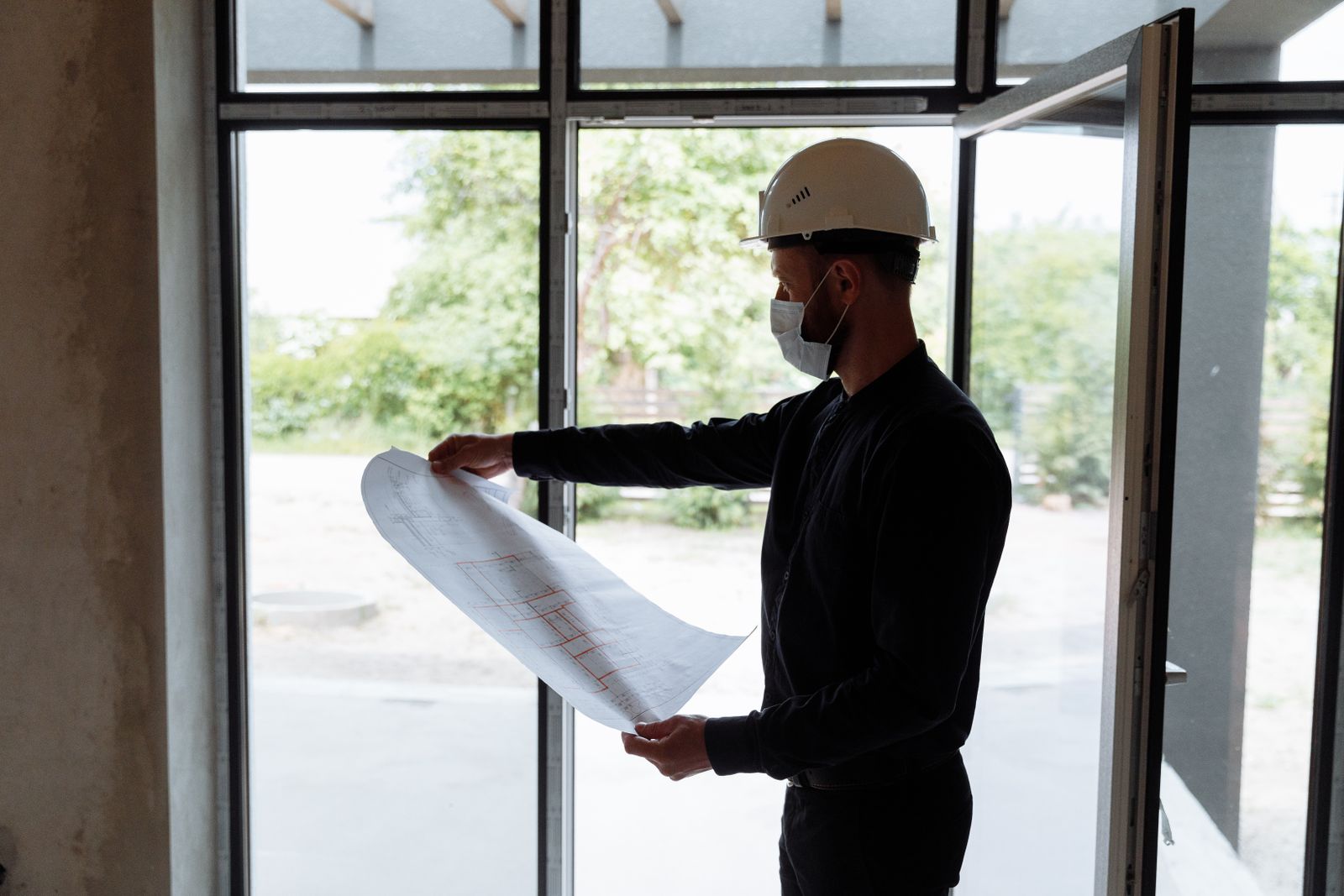 Ingenieur bestudeert bouwtekeningen tijdens een inspectie