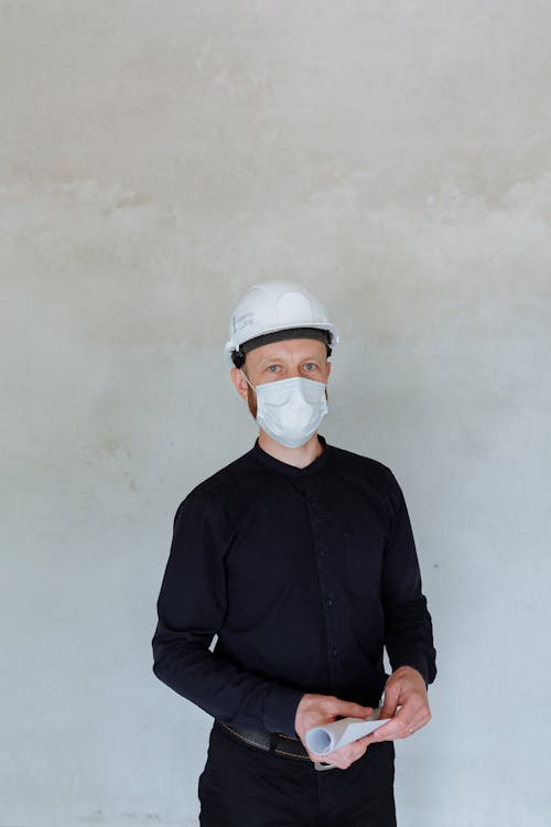 Man in Blue Long Sleeves wearing Face Mask and Hard Hat 