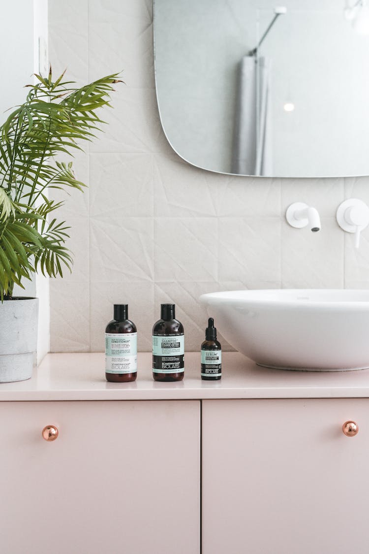 Black And White Bottles Beside White Ceramic Sink