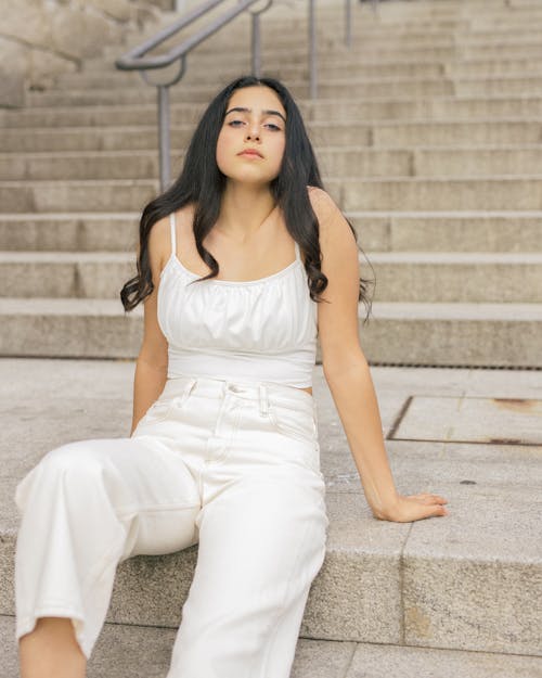 Free Beautiful Model in White Clothes Sitting on Concrete Steps Stock Photo