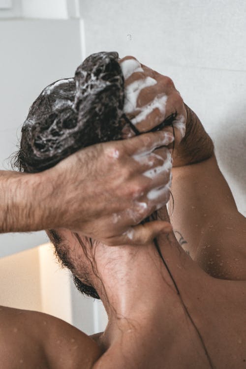Back View of a Person Shampooing His Hair