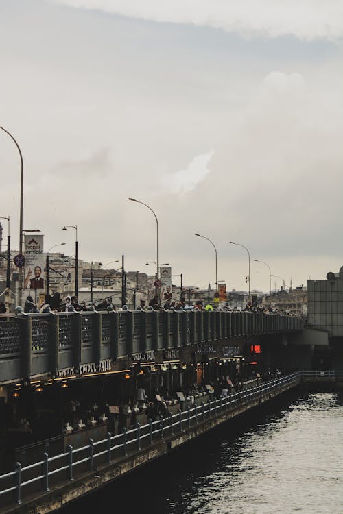 People Standing on the Bridge Fishing