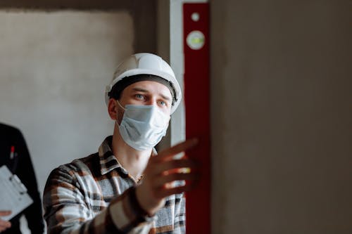 A Man in Plaid Long Sleeves Wearing Face Mask and a Hard Hat
