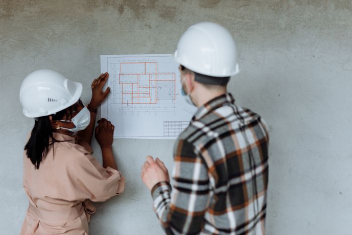 Architects in hard hats reviewing blueprints, Thirdman on Pexels