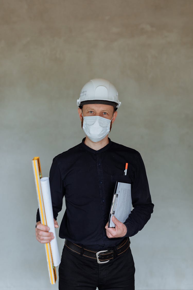 Portrait Of An Architect Wearing A Hard Hat And A Face Mask