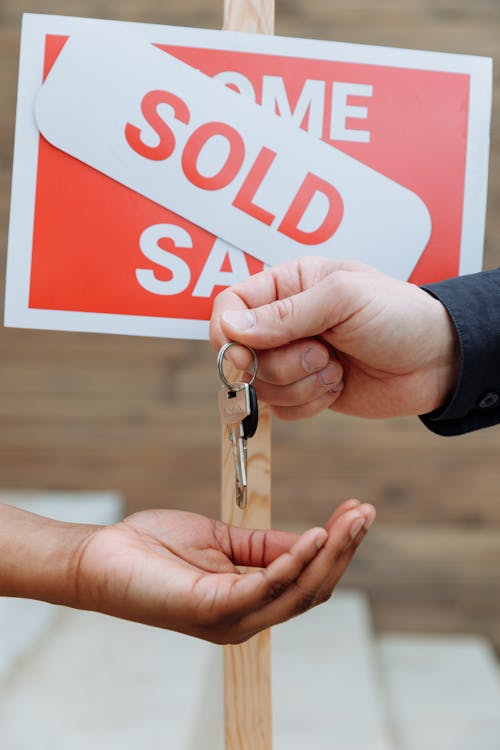 Free Person Handing Out Keys to Another Person Stock Photo