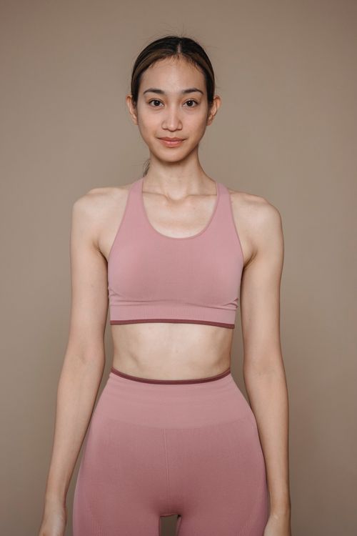 Free Portrait of a confident woman in pink sportswear showcasing fitness and health. Stock Photo
