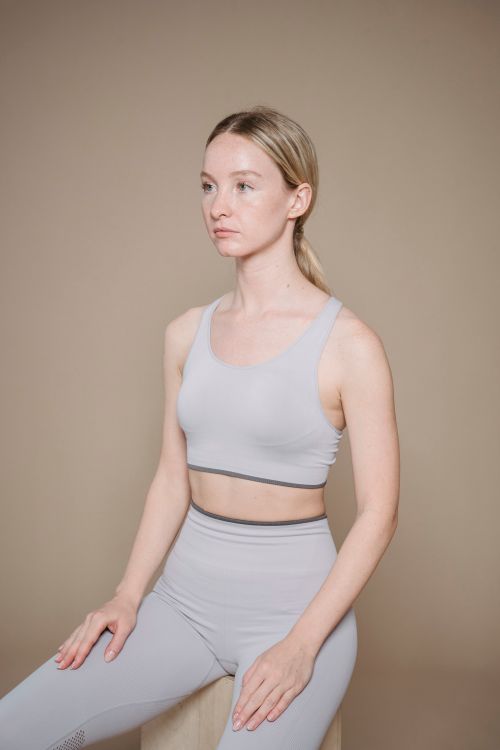 Free Caucasian woman in sports bra and leggings in studio portrait, highlighting modern activewear. Stock Photo
