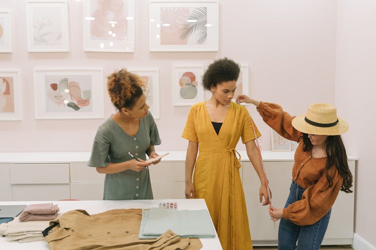 Woman Wearing A Hat Measuring A Woman's Arm