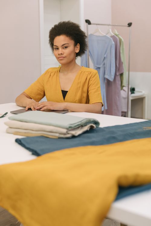 Free A woman working in a design studio with fabrics on the table. Stock Photo