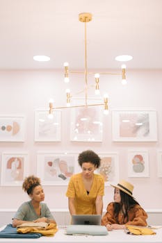 Diverse team of three women collaborating in a stylish design studio setting.