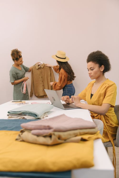 Free Team of diverse fashion designers working on new clothing line in a creative studio setting. Stock Photo