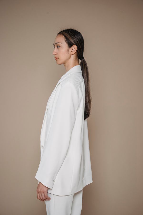 Woman wearing a cape blazer over a slip skirt