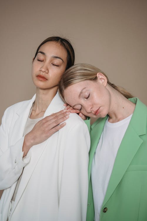 A Woman in Green Blazer Leaning on a Woman's Shoulder