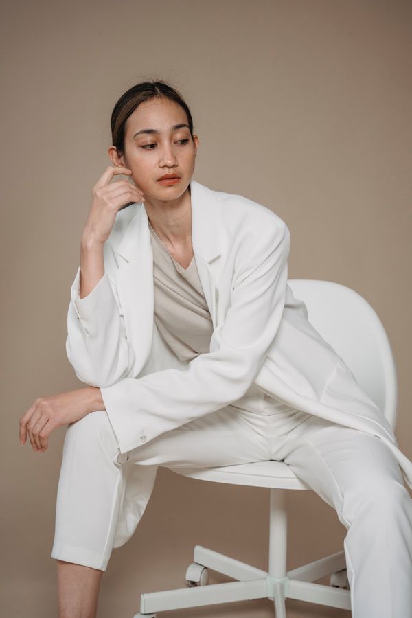 Woman wearing cream suit with gold jewelry