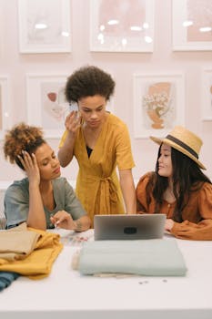 Three diverse women working together on a business project with laptop and phone.